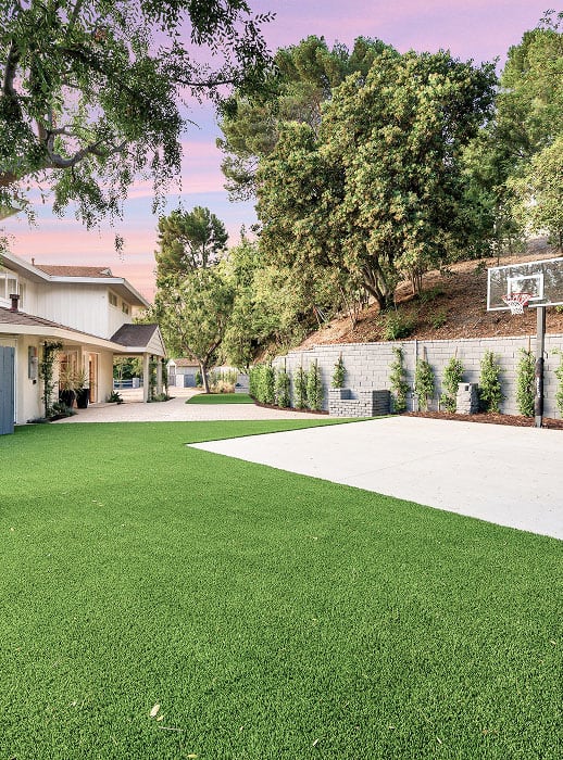 Beautiful backyard with lush green turf and modern hardscape features.